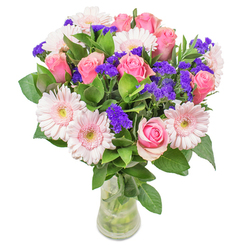 Composed with the deft touch of an experienced florist, this arrangement is inspired by the gentle beauty of Harmondsworth's rural charm. Blush-toned gerberas nestle seamlessly beside classic pink roses, their colours blending like sunrise over the village. Peppered between, bold purple statice create lively punctuation, each spike a cheerful surprise against the sweeping pinks. The foliage is fresh and abundant, echoing the morning dew on leaves around Harmondsworth Green, anchoring the swirling blooms with cool vividness. Framed in a simple glass vase, the pastoral hues seem to softly glow, capturing both warmth and modest elegance. Whether gifted to lift a friend's spirits at Harmondsworth Community Centre, or displayed as a bright accent in a riverside cottage, this bouquet is a joyful testament to local artistry, honest craftsmanship, and the enduring optimism of our village.